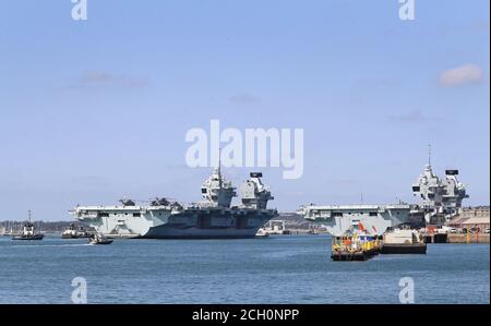 La Royal Navy Aircraft Carrier HMS Queen Elizabeth (a sinistra) passa l'HMS Prince of Wales quando ritorna alla base navale di Portsmouth per raccogliere le forniture prima della navigazione per l'esercizio fisico per prepararla alla preparazione del Carrier Strike Group prima del suo primo schieramento operativo il prossimo anno. Foto Stock