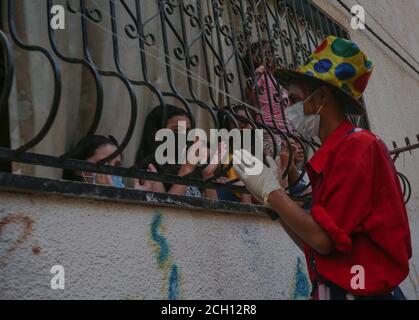 Khan Yunis, Palestina. 10 settembre 2020. Un giovane palestinese vestito da clown ha organizzato uno spettacolo di strada per intrattenere i bambini a casa a causa dell'epidemia di Coronavirus COVID19 a Khan Yunis, nella striscia di Gaza meridionale. (Foto di Yousef Masoud/INA Photo Agency) Credit: Sipa USA/Alamy Live News Foto Stock