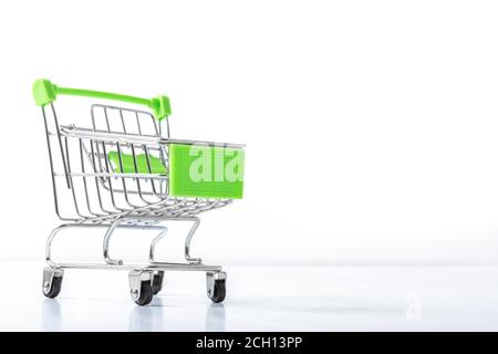 Primo piano di supermercato spingere carrello per lo shopping su sfondo bianco. Il carrello è il simbolo dello shopping in corso. Concetto di shopping. Spazio di copia per Foto Stock