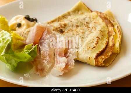 Gravlax con pancake servita foglie di insalata Foto Stock