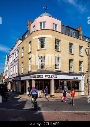 Patisserie Valerie - un ciclista passa Patisserie Valerie sull'angolo di una fila di negozi in Bridge Street, centro di Cambridge Regno Unito Foto Stock