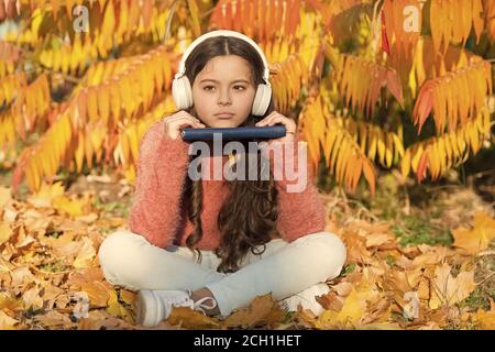 Oggi eLearning. Bambina imparare online sotto agli alberi con foglie di giallo. Bambino Piccolo elearning sulla soleggiata giornata autunnale. L'istruzione globale. eLearning per il futuro ambiente eLearning. Foto Stock