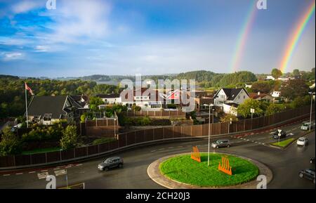 Doppio arcobaleno sulla città europea con la rotonda e le auto in primo piano - Stavanger Norvegia Foto Stock