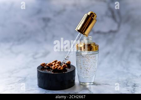 Vitamina C siero. Prodotto cosmetico naturale organico per la cura della pelle. Flacone contagocce di con vitamine naturali su fondo di marmo.flacone idratante di collagene Foto Stock