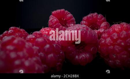 Vista macro dei lamponi. Primo piano di lampone fresco, deciso e gustoso. Spuntini estivi vegani organici crudi, frutti di bosco. Foto Stock