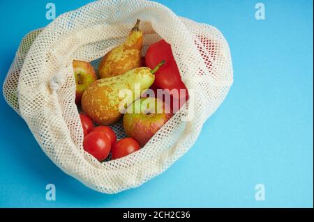 borsa in cotone per lo shopping di frutta e verdura su sfondo blu con spazio di copia, concetto per evitare sacchetti di plastica Foto Stock