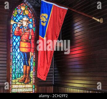 Cappella splendidamente illuminata presso l'accademia di addestramento del cadetto RCMP Depot a Regina, Saskatchewan, Canada. Le finestre in vetro colorato raffigurano due agenti RCMP. A sinistra c'è un constable in lutto; a destra c'è un trombettista che suona il reveille. La Cappella è un edificio classificato come patrimonio federale a causa delle sue associazioni storiche, e i suoi valori architettonici e ambientali. Il rilascio della proprietà non è necessario perché questa cappella è di proprietà del governo canadese ed è aperto al pubblico per cerimonie senza spese. Foto Stock