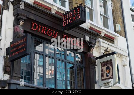 I segni rossi al neon del pub Dirty Dicks nella città di Londra. Foto Stock