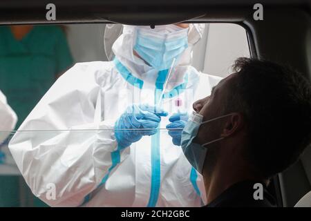 A Coruna-Spain -18 agosto 2020: Un operatore sanitario utilizza un test PCR (bocca e tampone nasale) su una persona all'interno di un'auto per determinare la presenza o l'assenza Foto Stock