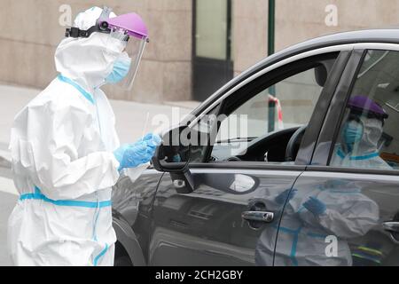 A Coruna-Spain -18 agosto 2020: Un operatore sanitario utilizza un test PCR (bocca e tampone nasale) su una persona all'interno di un'auto per determinare la presenza o l'assenza Foto Stock