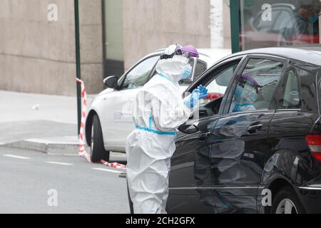 A Coruna-Spain -18 agosto 2020: Un operatore sanitario utilizza un test PCR (bocca e tampone nasale) su una persona all'interno di un'auto per determinare la presenza o l'assenza Foto Stock