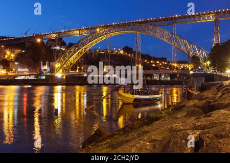Porto, Portogallo : Barche ormeggiate di notte accanto al ponte Dom Luis i sul fiume Douro. Foto Stock