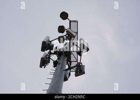 Una torre cellulare si trova in alto sopra un campo in ordine per supportare le comunicazioni moderne Foto Stock