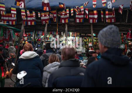 Kathmandu, Nepal - Dicembre 22 2019: Le persone non identificate camminano per diversi negozi sulla strada con bandiere colorate sopra il 22 dicembre a Kathmandu Foto Stock