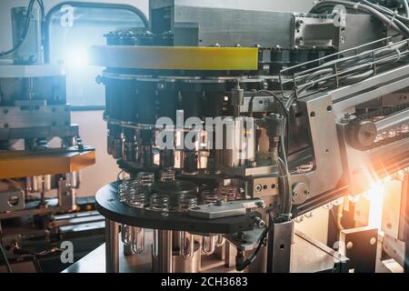 Macchina industriale per soffiaggio bottiglie in plastica da preforme in PET in fabbrica alimentare, primo piano. Foto Stock