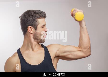 giovane bodybuilder che dimostra i suoi forti cervelli. vista laterale foto. concetto di salute. Foto Stock