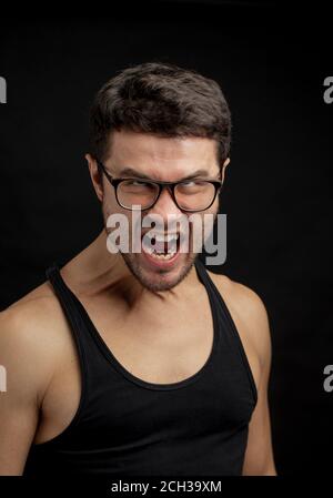 primo piano ritratto di un furioso uomo gridante isolato sfondo nero. copia spazio. Foto Stock