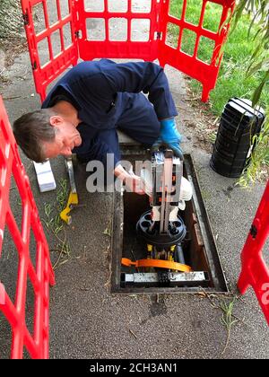 Ispezione dello splitter durante l'installazione della banda larga in fibra piena a. una casa domestica Foto Stock