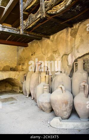 Vasi di argilla (anfore) in un negozio di alimentari (bottega) a Ercolano, una città romana, distrutta dall'eruzione del Vesuvio nel 79 d.C. Foto Stock