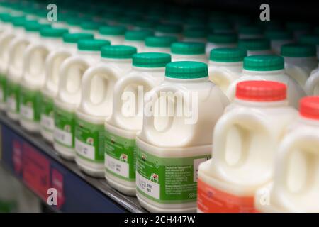 Cartoni di plastica di latte in vendita in un supermercato. Foto Stock
