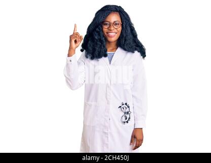 Bella donna opticista afroamericana con occhiali da optometria puntando il dito con successo idea. Uscita e felice. Numero uno. Foto Stock