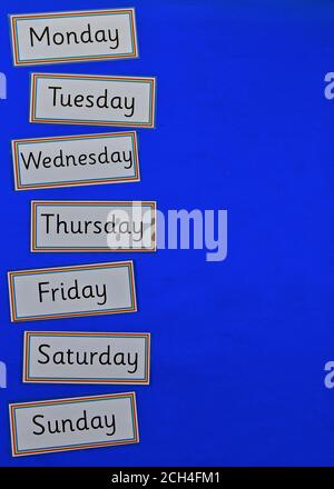 Concetto di educazione flatlay con copyspace su sfondo blu, con i giorni della settimana. Foto Stock