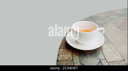 Tazza da tè in porcellana bianca su un tavolo rotondo, isolata, a fuoco selettivo Foto Stock