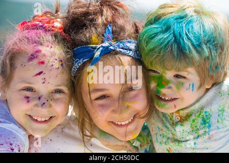 Viso per bambini dipinto su colorato sfondo holi, primo piano. Festival dei colori. I bambini disegna le vernici. Foto Stock