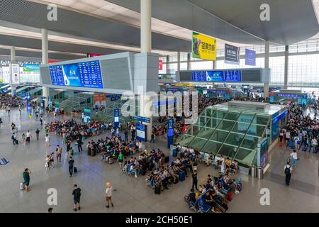 Passeggeri in una stazione ferroviaria trafficata in Cina Foto Stock