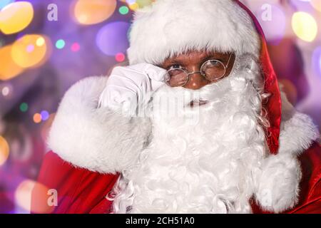 Babbo Natale afroamericano contro le luci offuscate Foto Stock