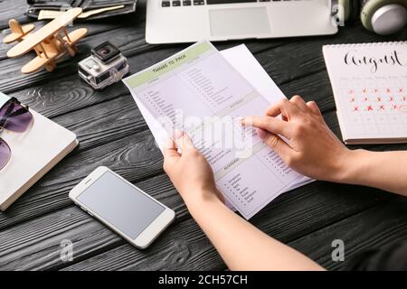 Donna che fa la lista di controllo delle cose da imballare per il viaggio Foto Stock
