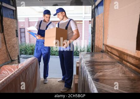 Caricatori che prelevano il carico dal camion Foto Stock