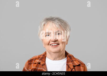 Donna anziana di stile su sfondo grigio Foto Stock