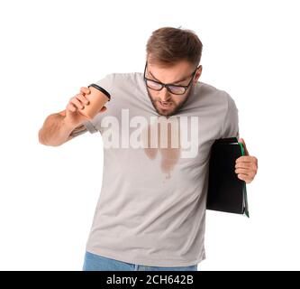 Giovane uomo d'affari stressato con macchie di caffè sulla sua t-shirt sfondo bianco Foto Stock