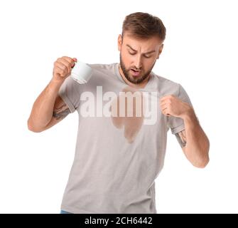 Giovane stressato con macchie di caffè sulla sua t-shirt sfondo bianco Foto Stock