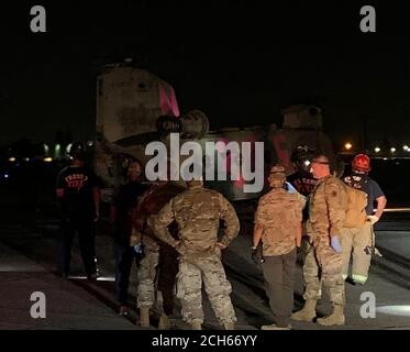 I guardiani nazionali della California, il dipartimento dei vigili del fuoco di Fresno e i servizi medici di emergenza della contea di Fresno attendono di dirigere gli evacuatori di un elicottero CH-47 Chinook della Brigata dell'aviazione di combattimento 40 dal fuoco del torrente alla linea di volo del 1106 del gruppo di manutenzione dell'aviazione di supporto a Fresno, California, 6 settembre 2020. Il Dipartimento militare della California ha evacuato oltre 200 persone lungo il bacino idrico di Mammoth Pool quando l'incendio del Creek è esploso in dimensioni. (STATI UNITI Air National Guard foto di Capt. Jason Sanchez) Foto Stock