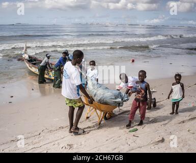 Dakar, Senegal. 13 Settembre 2020. I bambini del quartiere si uniscono a volontari per pulire una spiaggia nel sobborgo di Dakar, Senegal, il 13 settembre 2020. Dato che le trazioni provocate dalle onde marine e dalle precipitazioni piovose durante la stagione delle piogge hanno inquinato la costa, volontari e residenti locali hanno partecipato a un'attività di pulizia della spiaggia a Thiaroye-sur-Mer, una piccola città nel sobborgo di Dakar, sperando che più turisti sarebbero attratti da una spiaggia più pulita. Credit: Louis Denga/Xinhua/Alamy Live News Foto Stock