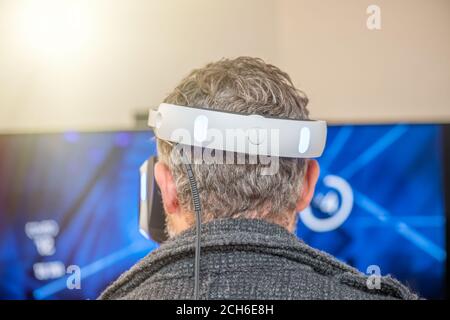 Vista posteriore di un uomo che gioca con visiera VR. Foto Stock