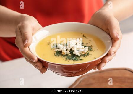 Donna con gustosa zuppa di popcorn in ciotola, primo piano Foto Stock