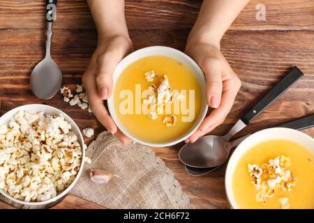 Donna con gustosa zuppa di popcorn nel recipiente Foto Stock