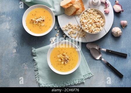 Ciotole con gustosa zuppa di popcorn su sfondo colorato Foto Stock