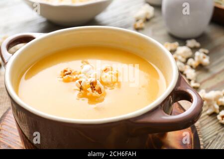 Pentola con gustosa zuppa di popcorn sul tavolo, primo piano Foto Stock