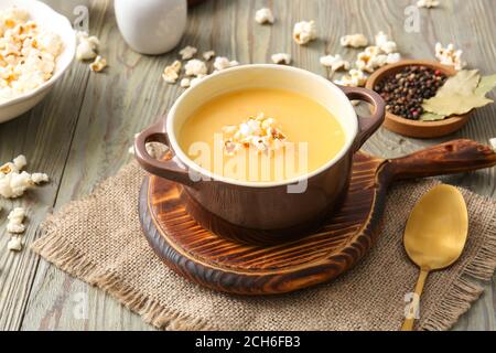 Pentola con gustosa zuppa di popcorn sul tavolo Foto Stock