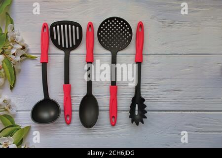 Posa piatta di utensili da cucina e utensili da cucina su legno sfondo Foto Stock