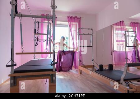 Donna che esercitano sulla macchina Pilates con gonna trasparente. Foto Stock