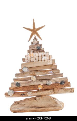La figura di un albero di Natale fatto di legno e conchiglie, con una stella marina. Il concetto di vacanze di nuovo anno presso il resort. Isolare. Foto Stock