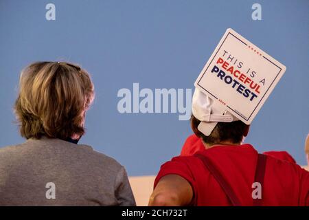 Henderson, NV, Stati Uniti. 13 Settembre 2020. Una donna mostra un cartello "questa è una protesta pacifica" fuori da Xtreme Manufacturing, il luogo di ritrovo per un evento della campagna Trump. La sede è stata piena di capacità e la maggior parte della folla è affluita fuori sulla strada. Credit: Young G. Kim/Alamy Live News Foto Stock