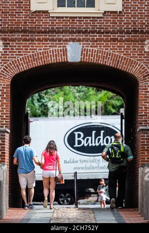 Filadelfia, Pennsylvania, USA - 17 giugno 2019: Arco di ingresso casa in mattoni rossi ai vecchi cortili di edifici residenziali, dietro l'arco visibile str Foto Stock