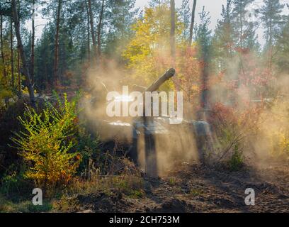 panzer T-64 in nuvole di polvere nella foresta d'autunno Foto Stock