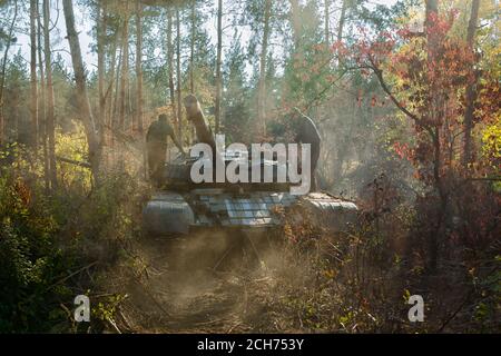 panzer T-64 in nuvole di polvere nella foresta d'autunno Foto Stock